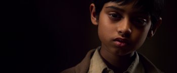Movie still from “Lone Survivor” (2013), directed by Peter Berg – A young boy is looking into the camera; Close Up shot, Over the shoulder angle
