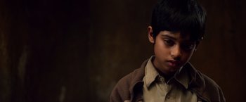 Movie still from “Lone Survivor” (2013), directed by Peter Berg – A young boy in a brown shirt and jacket; Close Up shot, High angle