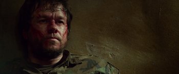 Movie still from “Lone Survivor” (2013), directed by Peter Berg – A person wearing a military uniform; Close Up shot, Over the shoulder angle