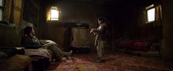 Movie still from “Lone Survivor” (2013), directed by Peter Berg – A young boy standing in the middle of a living room; Wide shot, Over the shoulder angle