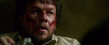 Movie still from “Lone Survivor” (2013), directed by Peter Berg – A person with blood on his face; Close Up shot, Overhead angle