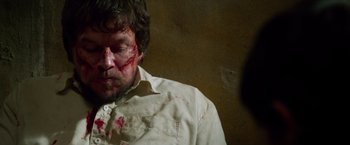 Movie still from “Lone Survivor” (2013), directed by Peter Berg – A man with blood all over his face; Close Up shot, High angle