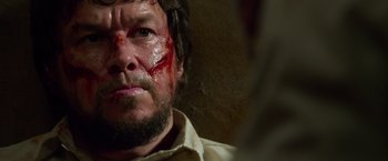 Movie still from “Lone Survivor” (2013), directed by Peter Berg – A person with blood on his face; Close Up shot, Over the shoulder angle