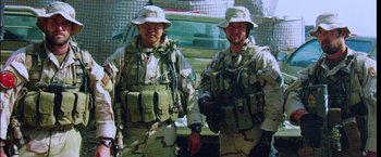 Movie still from “Lone Survivor” (2013), directed by Peter Berg – A couple of men standing next to each other; Medium shot, Low angle