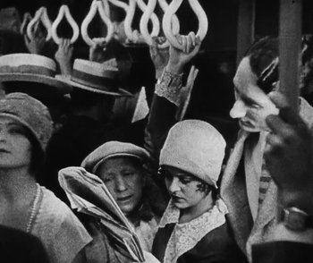 Movie still from “Lonesome” (1928), directed by Pál Fejös – A black and white photo of a group of people on a bus; Medium shot, High angle