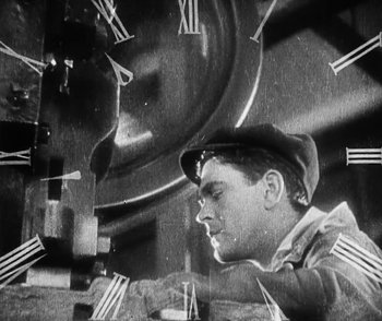 Movie still from “Lonesome” (1928), directed by Pál Fejös – An old photo of a man working on a clock; Medium shot, High angle