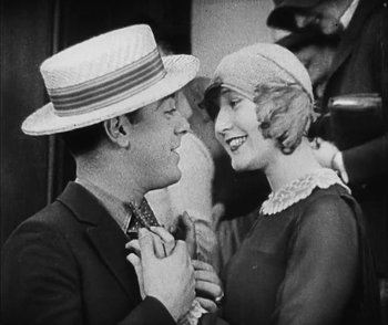 Movie still from “Lonesome” (1928), directed by Pál Fejös – A man and a woman are smiling at each other; Close Up shot, Low angle