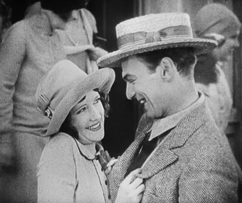 Movie still from “Lonesome” (1928), directed by Pál Fejös – An old photo of a man and a woman smiling; Medium shot, Low angle