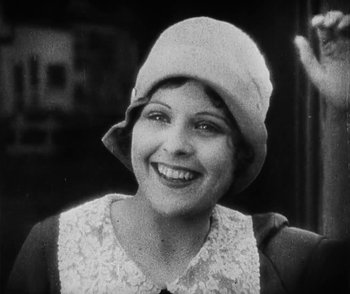 Movie still from “Lonesome” (1928), directed by Pál Fejös – An old black and white photo of a woman wearing a hat; Close Up shot, Low angle
