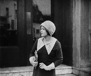 Movie still from “Lonesome” (1928), directed by Pál Fejös – An old photo of a woman holding an umbrella; Medium shot, High angle