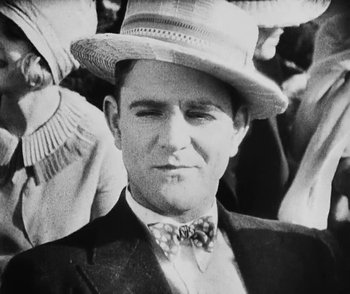 Movie still from “Lonesome” (1928), directed by Pál Fejös – A man wearing a suit and a straw hat; Close Up shot, Low angle