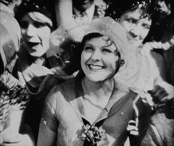 Movie still from “Lonesome” (1928), directed by Pál Fejös – An old photo of a group of people smiling for the camera; Close Up shot, High angle