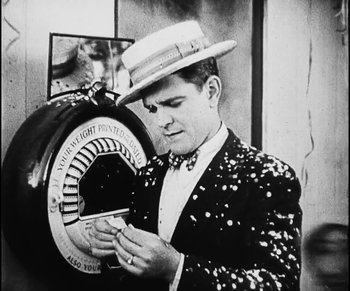 Movie still from “Lonesome” (1928), directed by Pál Fejös – A black and white photo of a man wearing a hat; Medium shot, High angle