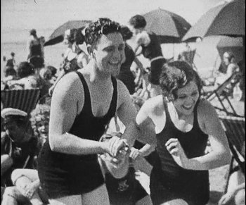 Movie still from “Lonesome” (1928), directed by Pál Fejös – A man and a woman in bathing suits on the beach; Medium shot, Low angle