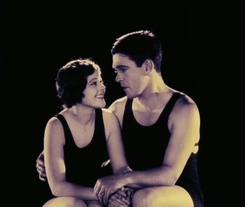 Movie still from “Lonesome” (1928), directed by Pál Fejös – A man and a woman sitting next to each other on the ground; Medium shot, Low angle