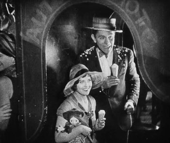 Movie still from “Lonesome” (1928), directed by Pál Fejös – A man and a woman are standing next to each other holding ice cream cones; Medium shot, High angle