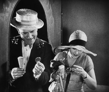 Movie still from “Lonesome” (1928), directed by Pál Fejös – An older man and woman looking at their cell phones; Medium shot, High angle