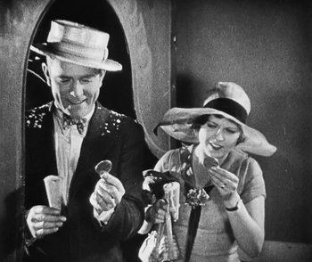 Movie still from “Lonesome” (1928), directed by Pál Fejös – An old photo of a man and a woman drinking wine; Medium shot, High angle