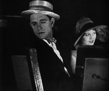 Movie still from “Lonesome” (1928), directed by Pál Fejös – A man and a woman wearing hats and a tie; Medium shot, Low angle
