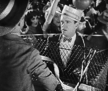 Movie still from “Lonesome” (1928), directed by Pál Fejös – An old photo of a man in a crowd; Medium shot, Over the shoulder angle