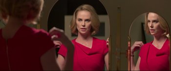 Movie still from “Long Shot” (2019), directed by Jonathan Levine – A woman in a red dress looking into a mirror; Medium shot, Over the shoulder angle
