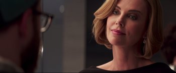 Movie still from “Long Shot” (2019), directed by Jonathan Levine – A woman with blonde hair and pink lipstick; Close Up shot, Over the shoulder angle