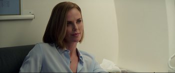 Movie still from “Long Shot” (2019), directed by Jonathan Levine – A woman in a blue shirt is sitting down; Close Up shot, Over the shoulder angle
