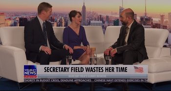 Movie still from “Long Shot” (2019), directed by Jonathan Levine – Three people sitting in front of a news paper; Medium shot, High angle