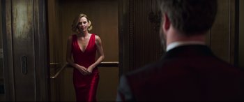 Movie still from “Long Shot” (2019), directed by Jonathan Levine – A woman in a red dress standing in front of a mirror; Medium shot, Over the shoulder angle
