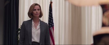 Movie still from “Long Shot” (2019), directed by Jonathan Levine – A woman standing in front of an american flag; Medium shot, Over the shoulder angle