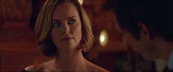 Movie still from “Long Shot” (2019), directed by Jonathan Levine – A beautiful woman with short blonde hair looking at the camera; Close Up shot, Over the shoulder angle