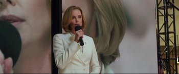 Movie still from “Long Shot” (2019), directed by Jonathan Levine – A woman in a white suit is holding a microphone; Close Up shot, Low angle
