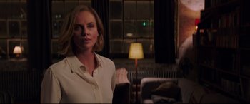 Movie still from “Long Shot” (2019), directed by Jonathan Levine – A woman in a white shirt is standing in front of a lamp; Medium shot, Over the shoulder angle