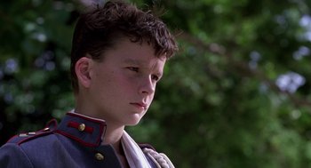 Movie still from “Lord of the Flies” (1990), directed by Harry Hook – A young man wearing a uniform looking to his left; Close Up shot, Low angle