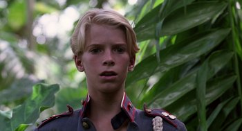 Movie still from “Lord of the Flies” (1990), directed by Harry Hook – A young man wearing a uniform in the woods; Close Up shot, Low angle