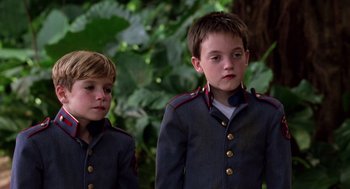 Movie still from “Lord of the Flies” (1990), directed by Harry Hook – Two young boys dressed in military style uniforms; Close Up shot, Low angle
