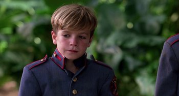 Movie still from “Lord of the Flies” (1990), directed by Harry Hook – A young boy in a military uniform looking at the camera; Close Up shot, High angle