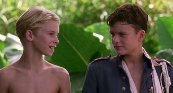 Movie still from “Lord of the Flies” (1990), directed by Harry Hook – A young man and a young woman standing next to each other; Close Up shot, Over the shoulder angle