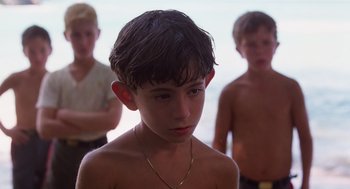 Movie still from “Lord of the Flies” (1990), directed by Harry Hook – Three young boys standing next to each other in a room; Close Up shot, Low angle