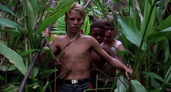 Movie still from “Lord of the Flies” (1990), directed by Harry Hook – A group of young men standing in the woods; Medium shot, Low angle
