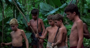 Movie still from “Lord of the Flies” (1990), directed by Harry Hook – A group of young boys standing next to each other holding sticks; Wide shot, High angle