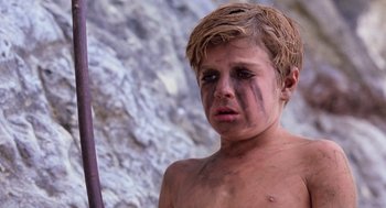 Movie still from “Lord of the Flies” (1990), directed by Harry Hook – A young boy with a knife in his mouth; Close Up shot, Low angle