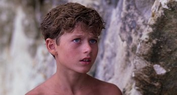 Movie still from “Lord of the Flies” (1990), directed by Harry Hook – A young boy with blue eyes stares into the distance; Close Up shot, Low angle