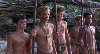 Movie still from “Lord of the Flies” (1990), directed by Harry Hook – A group of young men standing next to each other holding sticks; Medium shot, Low angle