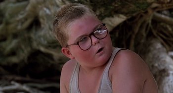 Movie still from “Lord of the Flies” (1990), directed by Harry Hook – A young boy wearing glasses and a white tank top; Close Up shot, Low angle