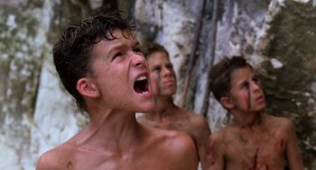 Movie still from “Lord of the Flies” (1990), directed by Harry Hook – A group of young men standing next to each other; Close Up shot, Low angle