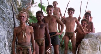 Movie still from “Lord of the Flies” (1990), directed by Harry Hook – A group of young men standing next to each other; Wide shot, Low angle