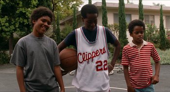 Movie still from “Love & Basketball” (2000), directed by Gina Prince-Bythewood – A group of young men standing next to each other on top of a basketball court; Medium shot, Low angle