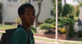 Movie still from “Love & Basketball” (2000), directed by Gina Prince-Bythewood – A young man standing on the side of the street; Close Up shot, Over the shoulder angle