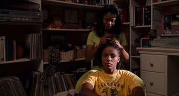 Movie still from “Love & Basketball” (2000), directed by Gina Prince-Bythewood – A woman is combing the hair of a young man; Close Up shot, Over the shoulder angle